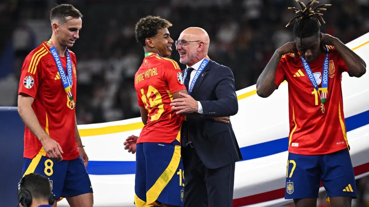 Euro 2024: Spanien - England: 15.07.2024, Berlin: Fußball, UEFA Euro 2024, EM, Finale, Spanien - England, Olympiastadion Berlin, Spaniens Lamine Yamal (2.vl) und Spaniens Trainer Luis de la Fuente umarmen sich nach dem Sieg im Finale. Foto: Tom Weller/dpa +++ dpa-Bildfunk +++