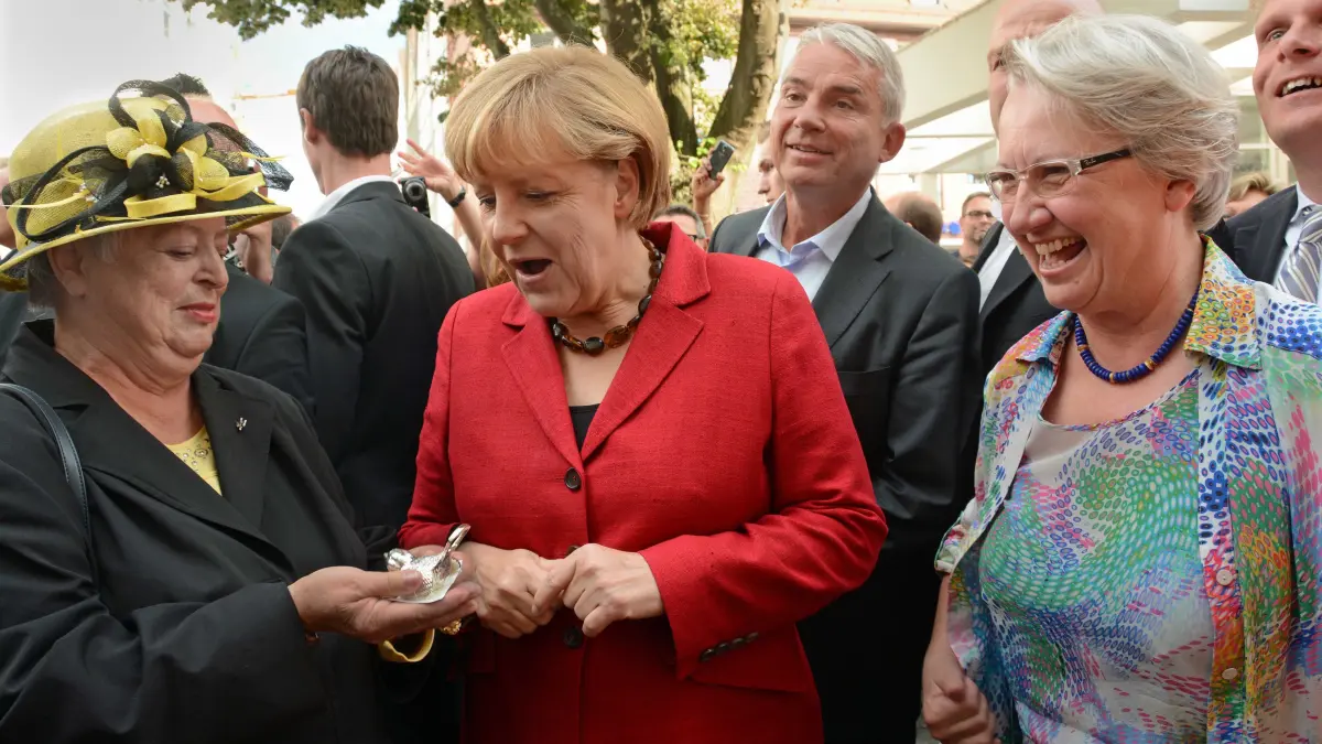 Malischewski Helga, Merkel Angela, Schavan Annette: Helga Malischewski überreicht Angela Merkel einen versilberten Ulmer Spatz, rechts Annette Schavan