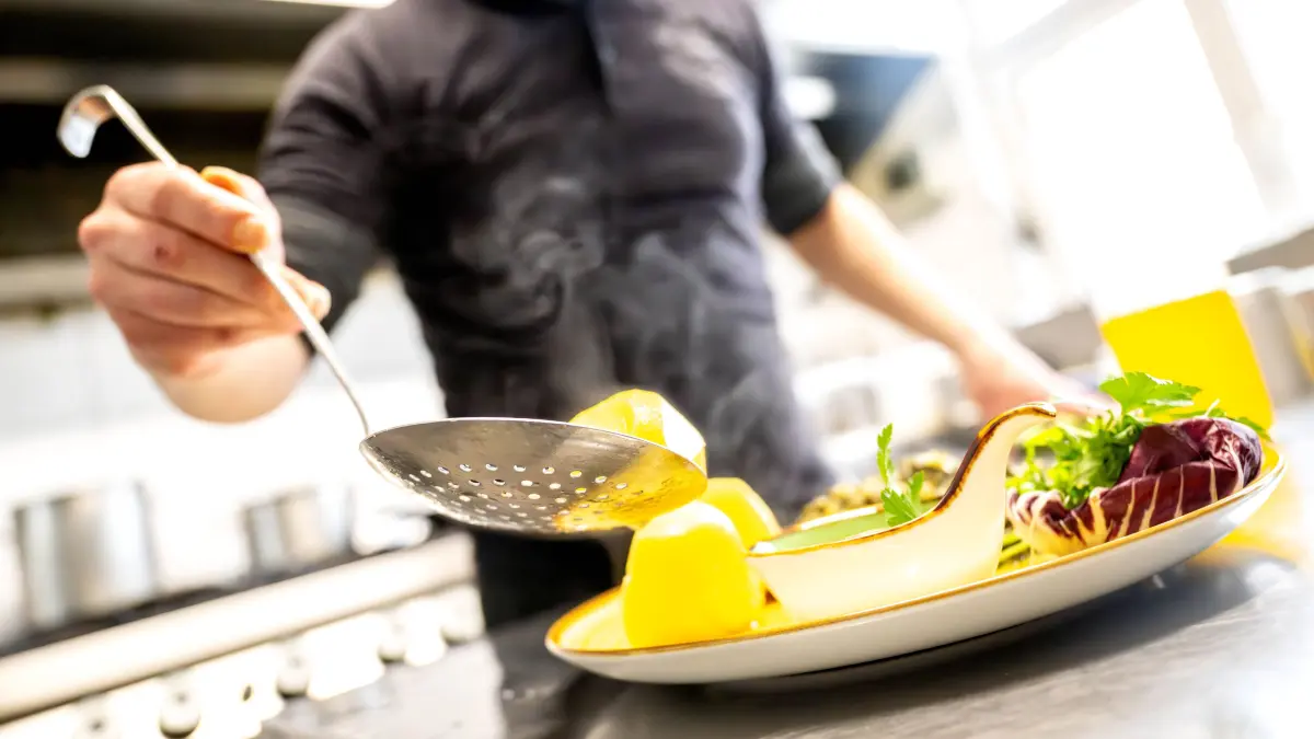 Essen wird in einem Restaurant auf einem Teller angerichtet. Der Hotel- und Gaststättenverband Dehoga in Niedersachsen sieht eine Chance, dass die Rückkehr zum normalen Mehrwertsteuersatz auf Restaurant-Essen doch noch abgewendet werden könnte. Die Bundesregierung hatte sich nach Angaben der Chefhaushälter von SPD, Grünen und FDP darauf verständigt, dass auf Speisen in der Gastronomie von Januar an wieder eine Umsatzsteuer von 19 Prozent statt 7 Prozent gilt. +++ dpa-Bildfunk +++