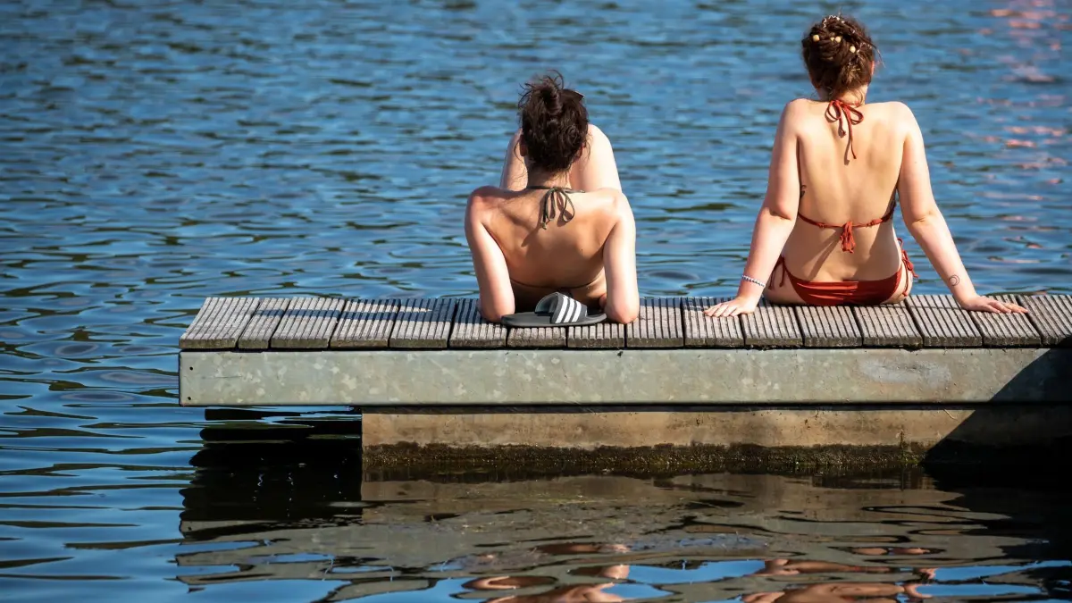 Baden im Rothsee: ARCHIV - 03.06.2019, Bayern, Birkach: Jugendliche sitzen auf einem Steg am Rothsee. (zu dpa: «Wasserqualität in Bayerns Badeseen ist hervorragend») Foto: Daniel Karmann/dpa +++ dpa-Bildfunk +++