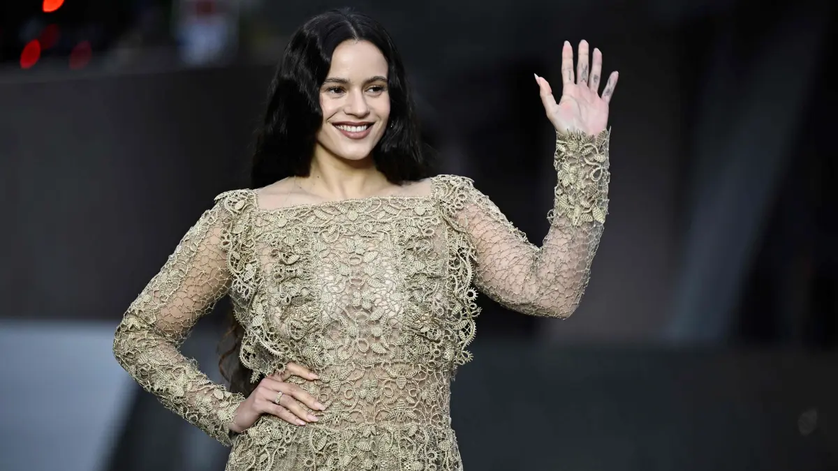 Spanish singer Rosalia greets as she arrives on the red carpet for 'The Prelude to the Olympics' at The Fondation Louis Vuitton in Paris on July 25, 2024, ahead of the 2024 Paris Olympics. (Photo by JULIEN DE ROSA / AFP)