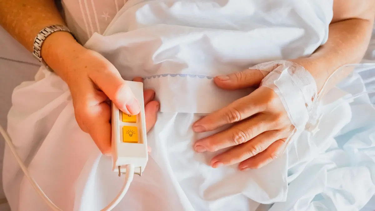 BEACHTEN: NPG-erweiterte Lizenz, Kranke Frau im Bett drückt die Serviceknopf Klingel, die sie von der Krankenschwester bekommen hat. Download am 26.7.2024 für MEGE, Bildnr.: 331328236, Foto: Joaquin Corbalan/stock.adobe.com