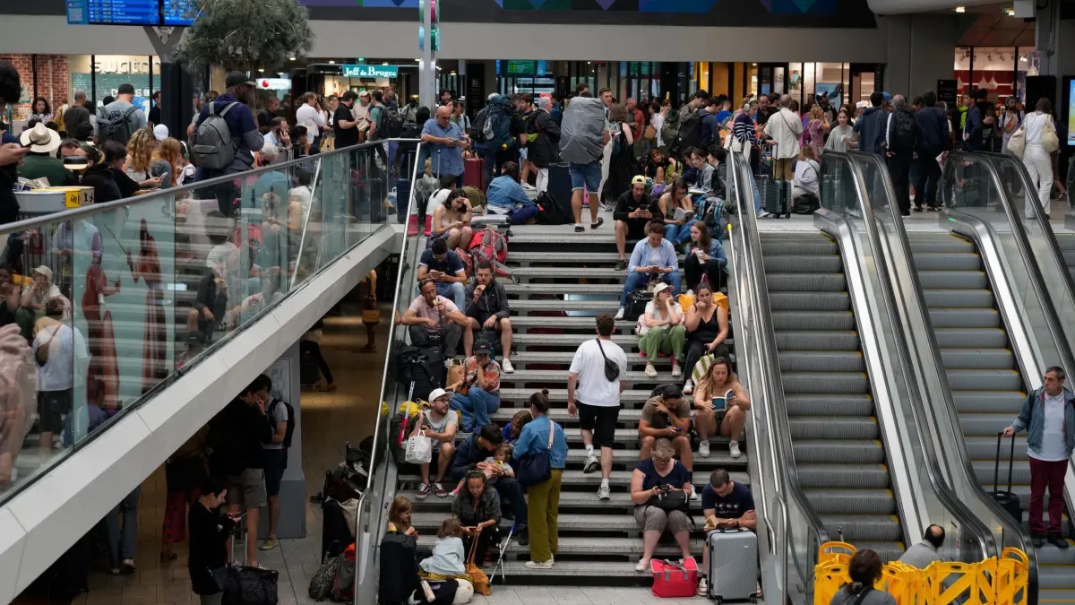 Vor Olympia: Brandanschläge auf Schnellzugnetz in Frankreich: 26.07.2024, Frankreich, Paris: Reisende sitzen auf einer Treppe am Gare de Montparnasse vor den Olympischen Sommerspielen 2024. Wenige Stunden vor der Eröffnung der Olympischen Spiele in Paris haben Unbekannte Brandanschläge auf mehreren Anlagen des französischen Schnellzugnetzes verübt. Der Schnellzugverkehr auf der Atlantik-, Nord- und Ostachse sei derzeit stark beeinträchtigt, teilte die französische Bahn SNCF mit. Foto: Yasin Dar/AP +++ dpa-Bildfunk +++