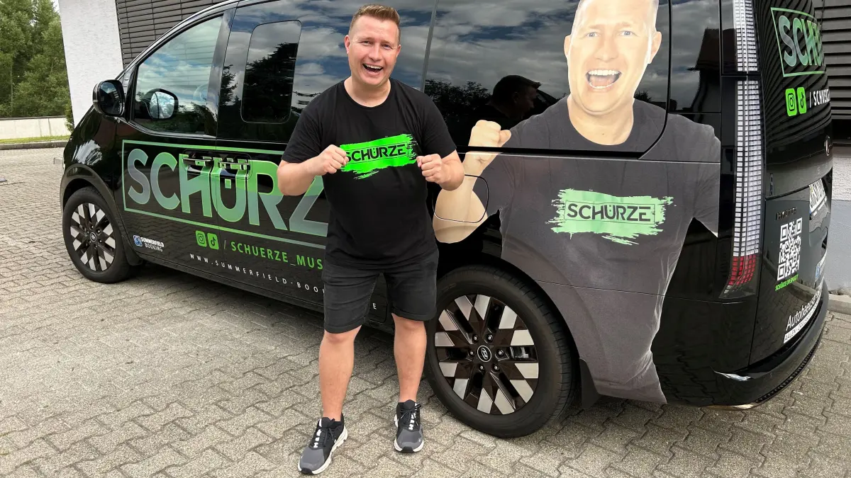 Schürze posiert vor seinem neuen Tourbus.