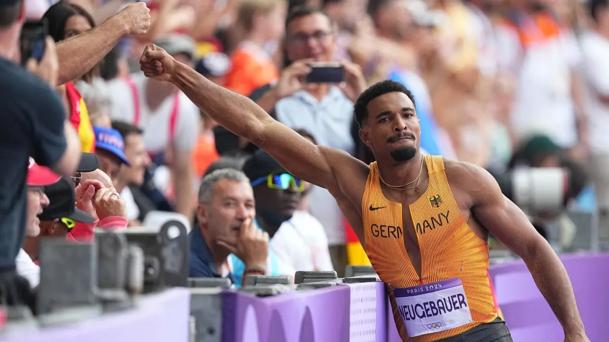 Paris 2024 - Leichtathletik: 02.08.2024, Frankreich, Saint-Denis: Olympia, Paris 2024, Leichtathletik, Stade de France, Vorkampf, Zehnkampf, Männer, Weitsprung, Leo Neugebauer aus Deutschland klatscht mit einem Unterstützer ab. Foto: Michael Kappeler/dpa +++ dpa-Bildfunk +++