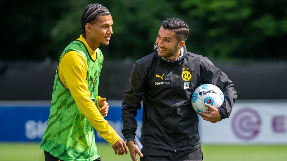 Trainingslager Borussia Dortmund: 03.08.2024, Schweiz, Bad Ragaz: Fußball: Bundesliga, Trainingslager Borussia Dortmund: Paris Brunner (l.) scherzt mit Trainer Nuri Sahin. Foto: David Inderlied/dpa - WICHTIGER HINWEIS: Gemäß den Vorgaben der DFL Deutsche Fußball Liga bzw. des DFB Deutscher Fußball-Bund ist es untersagt, in dem Stadion und/oder vom Spiel angefertigte Fotoaufnahmen in Form von Sequenzbildern und/oder videoähnlichen Fotostrecken zu verwerten bzw. verwerten zu lassen. +++ dpa-Bildfunk +++