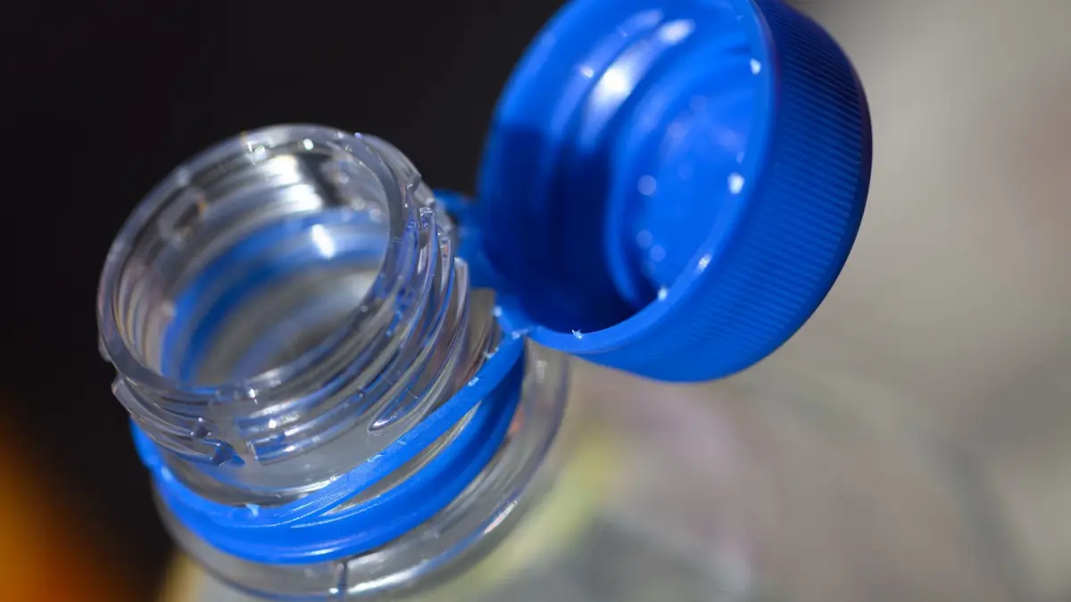 Deckel bei Getränken: PRODUKTION - 26.06.2024, Sachsen, Dresden: Eine Wasserflasche mit geöffneten Verschluss steht auf einem Tisch. Um den Müll in der Landschaft zu verringern, sind vom 3. Juli 2024 an lose Verschlusskappen bei bestimmten Getränken verboten. Das betrifft Einwegverpackungen, die ganz oder teilweise aus Kunststoff bestehen – etwa Saftkartons oder Einweg-PET-Flaschen – mit einem Volumen bis zu drei Litern. (zu dpa: «Experte: Fest angebundene Deckel nicht logisch») Foto: Robert Michael/dpa +++ dpa-Bildfunk +++