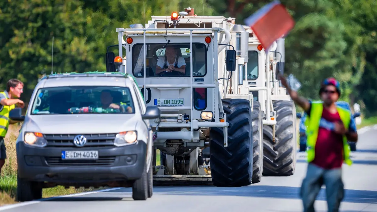 Vibrofahrzeuge bei Bodenuntersuchung für Geothermie-Projekt: PRODUKTION - 14.08.2024, Mecklenburg-Vorpommern, Parchim: Vibrofahrzeuge sind auf einer Messfahrt und sammeln bei seismische Untersuchung erste Daten für die Umsetzung eines Geothermie-Projekts der Stadtwerke. Mit dem akustischen Verfahren zur umweltfreundlichen Lagerstättenerkundung sollen erste Daten für ein mögliches Geothermieprojekt gesammelt werden. Die Stadtwerke wollen mit einer hydrothermale Geothermieanlage zukünftig einen Großteil der Gebäude umweltfreundlichen mit Erdwärme versorgen. (zu dpa: «Parchim will mit Wasser aus zwei Kilometern Tiefe heizen») Foto: Jens Büttner/dpa +++ dpa-Bildfunk +++