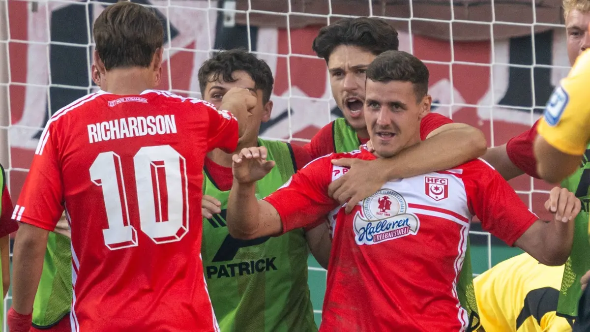 Hallescher FC - FC St. Pauli: 16.08.2024, Sachsen-Anhalt, Halle (Saale): Fußball: DFB-Pokal, Hallescher FC - FC St. Pauli, 1. Runde, Leuna-Chemie-Stadion. Halles Marius Hauptmann (r) hat soeben zum 2:1 getroffen. Foto: Hendrik Schmidt/dpa - WICHTIGER HINWEIS: Gemäß den Vorgaben der DFL Deutsche Fußball Liga bzw. des DFB Deutscher Fußball-Bund ist es untersagt, in dem Stadion und/oder vom Spiel angefertigte Fotoaufnahmen in Form von Sequenzbildern und/oder videoähnlichen Fotostrecken zu verwerten bzw. verwerten zu lassen. +++ dpa-Bildfunk +++