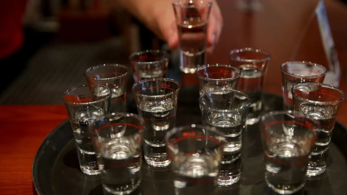 Schnaps: ARCHIV - 04.10.2015, Hamburg: Eine Hand greift in einer Gaststätte nach einem gefüllten Schnapsglas. (zu dpa: «Wodka, Korn & Co: Mehr als 76 Millionen Liter kamen aus NRW») Foto: Axel Heimken/dpa +++ dpa-Bildfunk +++