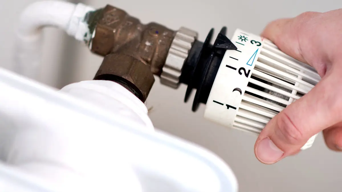 Kommunen suchen nach Energie-Einsparpotenzialen: ARCHIV - 07.03.2019, Niedersachsen, Hannover: ILLUSTRATION - Eine Frau dreht am Thermostat einer Heizung. (zu dpa: «Wärmeplanung: Kommunen bekommen Geld vom Land») Foto: Hauke-Christian Dittrich/Deutsche Presse-Agentur GmbH/dpa +++ dpa-Bildfunk +++