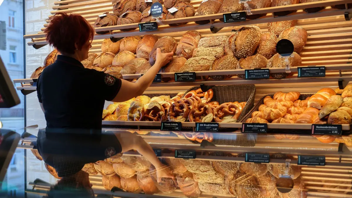 Eine Mitarbeiterin räumt Mischbrot in die Auslage einer Bäckerei. Am gleichen Tag gibt die Mindestlohnkommission ihren Vorschlag für den Mindestlohn 2024 bekannt. +++ dpa-Bildfunk +++