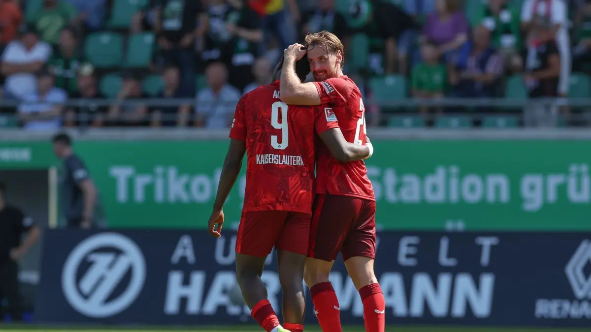 SC Preußen Münster - 1. FC Kaiserslautern: 24.08.2024, Nordrhein-Westfalen, Münster: Fußball: 2. Bundesliga, SC Preußen Münster - 1. FC Kaiserslautern, 3. Spieltag im Stadion an der Hammer Straße. Kaiserslauterns Torschütze Ragnar Ache (l) feiert den Sieg bei Spielende mit Jannis Heuer (r). Foto: Friso Gentsch/dpa - WICHTIGER HINWEIS: Gemäß den Vorgaben der DFL Deutsche Fußball Liga bzw. des DFB Deutscher Fußball-Bund ist es untersagt, in dem Stadion und/oder vom Spiel angefertigte Fotoaufnahmen in Form von Sequenzbildern und/oder videoähnlichen Fotostrecken zu verwerten bzw. verwerten zu lassen. +++ dpa-Bildfunk +++