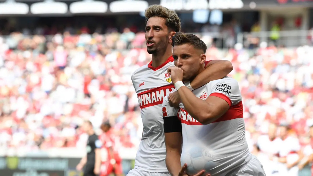 Stuttgart's Bosnian forward #09 Ermedin Demirovic (R) celebrates scoring the opening goal with Stuttgart's German midfielder #16 Atakan Karazor during the German first division Bundesliga football match between SC Freiburg and VfB Stuttgart in Freiburg, southwestern Germany, on August 24, 2024. (Photo by Thomas KIENZLE / AFP) / DFL REGULATIONS PROHIBIT ANY USE OF PHOTOGRAPHS AS IMAGE SEQUENCES AND/OR QUASI-VIDEO