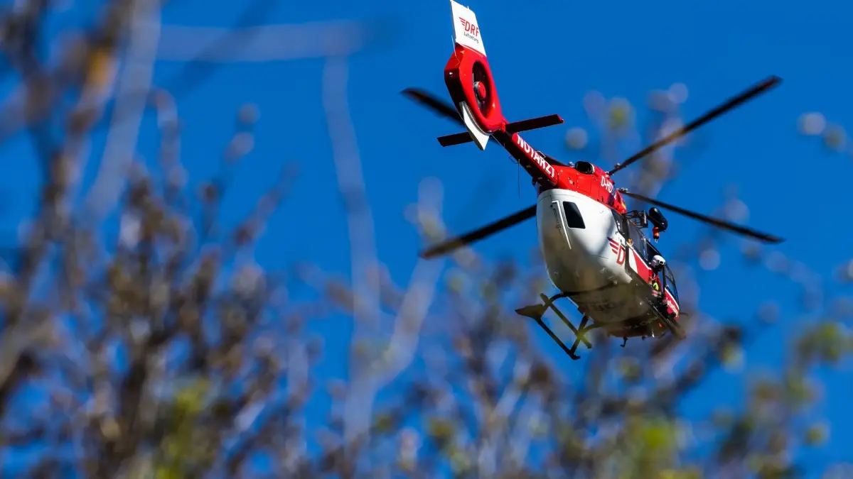 ARCHIV - 23.04.2021, Baden-Württemberg, Ihringen: Ein Helikopter der DRF Luftrettung schwebt am Himmel über einem Waldstück. (zu dpa: «Drei Verletzte bei Unfall zwischen Motorrad und Auto») Foto: Philipp von Ditfurth/dpa +++ dpa-Bildfunk +++
