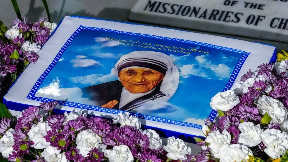 Gedenken an Mutter Teresa: 26.08.2024, Indien, Kolkata: Ein mit Blumen geschmücktes Porträt der Heiligen Teresa steht auf dem Grab bei den «Missionarinnen der Nächstenliebe», des von Mutter Teresa gegründeten Ordens, anlässlich ihres Geburtstages. Foto: Bikas Das/AP +++ dpa-Bildfunk +++
