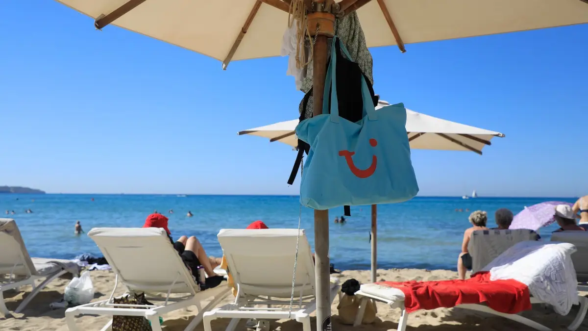 Tui-Tasche am Strand von Palma: ARCHIV - 01.10.2023, Spanien, Palma: Nach wie vor ist Mallorca bei Urlaubern beliebt. (zu dpa: «Tui erwartet starke Nachfrage in Herbstferien») Foto: Clara Margais/dpa/dpa-tmn +++ dpa-Bildfunk +++