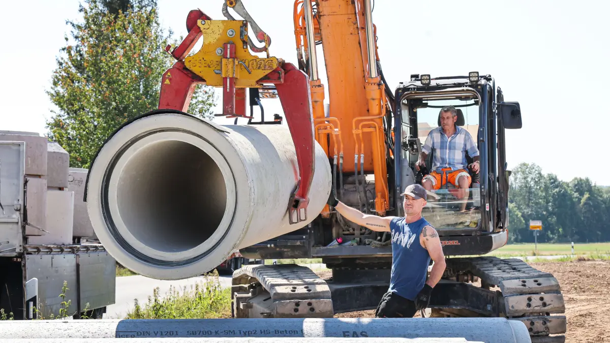 Arbeiter laden am vergangenen Mittwoch in der spätsommerlichen Hitze Rohre für den Straßenbau ab.