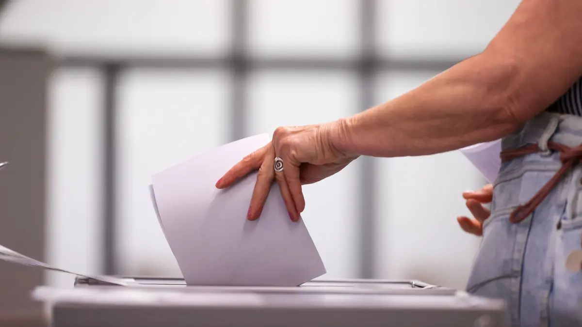 Wahlurne: ACHTUNG: SPERRFRIST 1. SEPTEMBER 08:00 UHR. - ARCHIV - 06.06.2021, Sachsen-Anhalt, Wittenberg: Eine Frau wirft ihren Stimmzettel in eine Urne in einem Wahllokal. (Archivbild) (zu dpa: «Wahllokale in Sachsen geöffnet») Foto: Jan Woitas/dpa-Zentralbild/dpa +++ dpa-Bildfunk +++