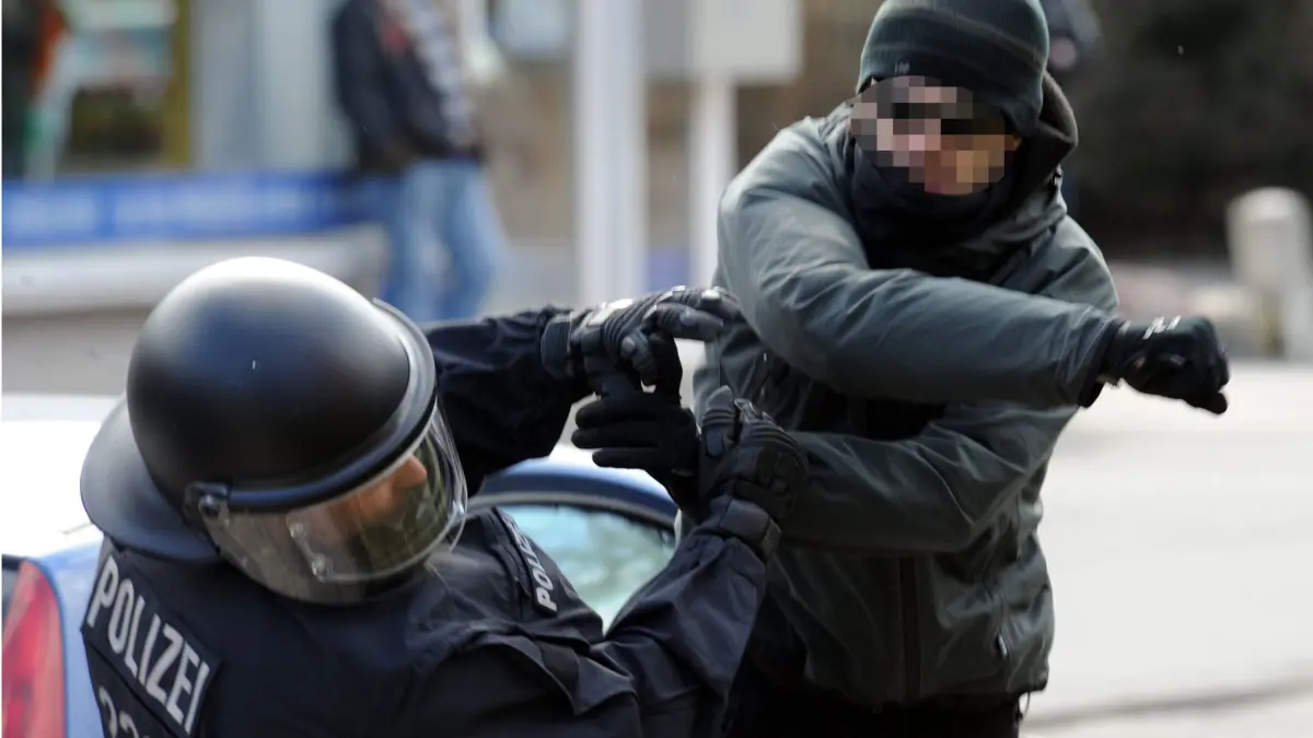 ARCHIV - 26.03.2011, Schleswig-Holstein, Lübeck: Ein gewalttätiger Demonstrant schlägt einen Polizeibeamten nieder. Insgesamt 2658 Polizisten sind im vergangenen Jahr in Schleswig-Holstein im Dienst Opfer von Gewalt geworden. (zu dpa "Bei Widerstand gegen Polizisten im Norden fast 400 Beamte verletzt") Foto: Carsten Rehder/dpa +++ dpa-Bildfunk +++ | Verwendung weltweit