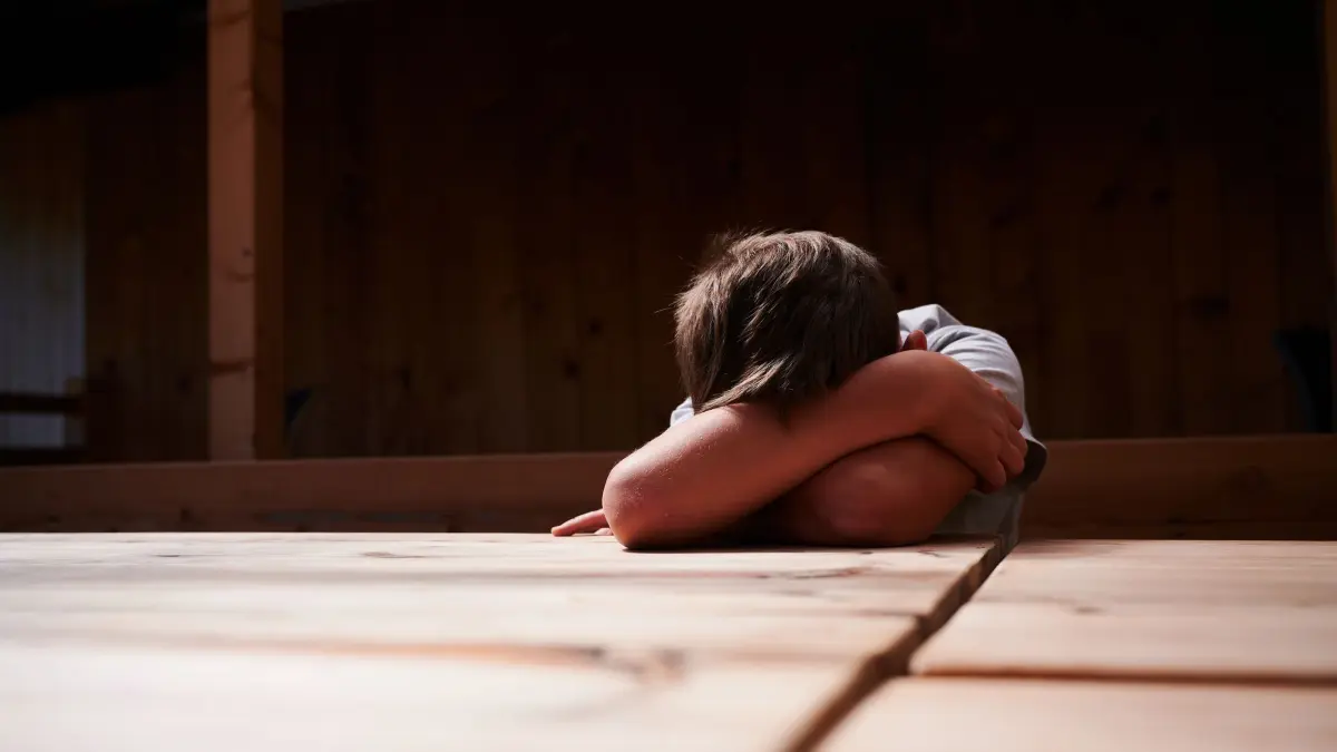 Ein Kind versteckt sein Gesicht unter seinen Armen: ILLUSTRATION - Weinen bedeutet Stress für den Körper. (zu dpa: «Warum habe ich nach dem Weinen Kopfweh?») Foto: Annette Riedl/dpa/dpa-tmn - Honorarfrei nur für Bezieher des dpa-Themendienstes +++ dpa-Themendienst +++