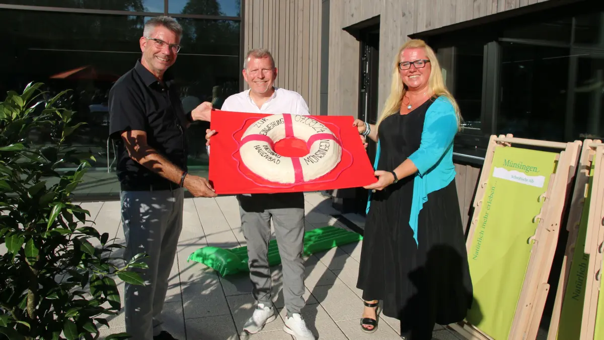 Eine leckere Torte zur Neueröffnung. Frank Hintzenstern, Mike Münzing und Julia Leibiger.JPG