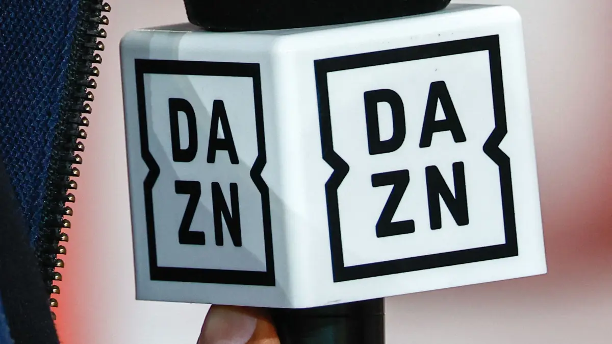(FILES) A journalist holds a microphone of British sports streaming and entertainment platform's DAZN, which broadcasts L1, during the French L1 football match between Lille LOSC and Paris Saint-Germain (PSG) at the Stade Pierre-Mauroy in Villeneuve-d'Ascq, northern France, on September 1, 2024. British streaming platform DAZN, which has been heavily criticised for the price of its France's football Ligue 1 subscription, is to launch a promotion on September 9, 2024, valid from 10 to 22 September, reducing the price of its annual subscription from 29.99 to 19.99 euros per month, the head of DAZN France told AFP. (Photo by DENIS CHARLET / AFP)