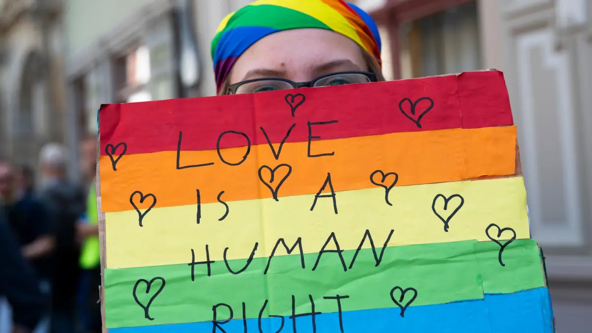 Eine Teilnehmerin trägt ein Plakat mit der Aufschrift "Love is a human right" beim Christopher Street Day in Pirna. Der CSD in Pirna hat in diesem Jahr besondere Brisanz, da in der Stadt seit einigen Monaten ein AfD-naher Oberbürgermeister regiert. +++ dpa-Bildfunk +++