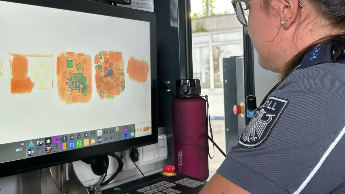 Eine Mitarbeiterin des Deutschen Zolls kontrolliert Gepäckstücke