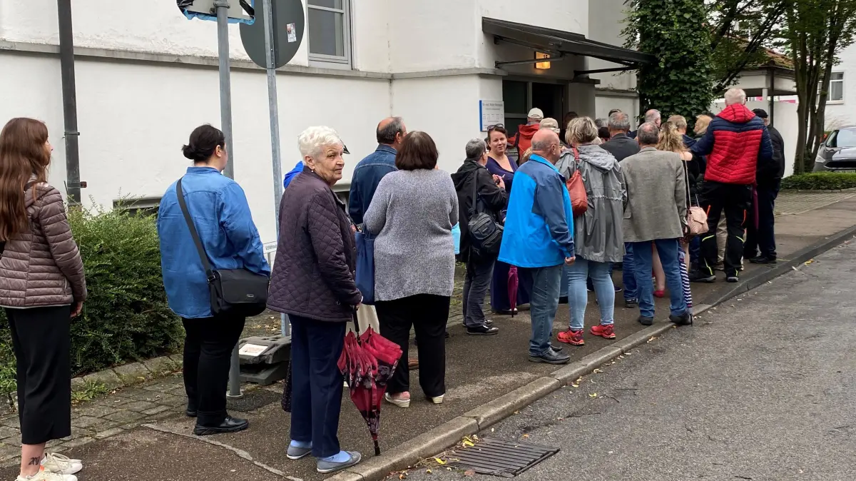 Patienten stehen vor der Praxis Dr. Walter Herrmann in der Rechbergstraße an, um an ihre Patientenakte zu kommen.