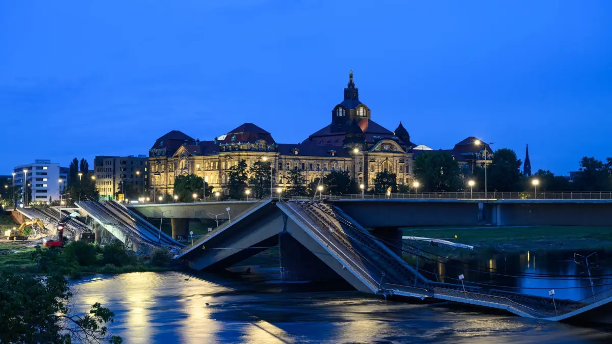 Brückeneinsturz in Dresden: 13.09.2024, Sachsen, Dresden: Mit Baggern werden weitere Teile der eingestürzten Carolabrücke abgerissen, dahinter ist die Staatskanzlei zu sehen. Im Zuge von Abrissarbeiten ist ein weiterer Abschnitt der Carolabrücke in Dresden eingebrochen. Es handelt sich um den Brückenstrang mit Straßenbahngleisen, der in der Nacht zum Mittwoch bereits teilweise in die Elbe gestürzt war. (zu dpa: «Beschädigter Teil der Carolabrücke wird komplett abgerissen») Foto: Robert Michael/dpa +++ dpa-Bildfunk +++