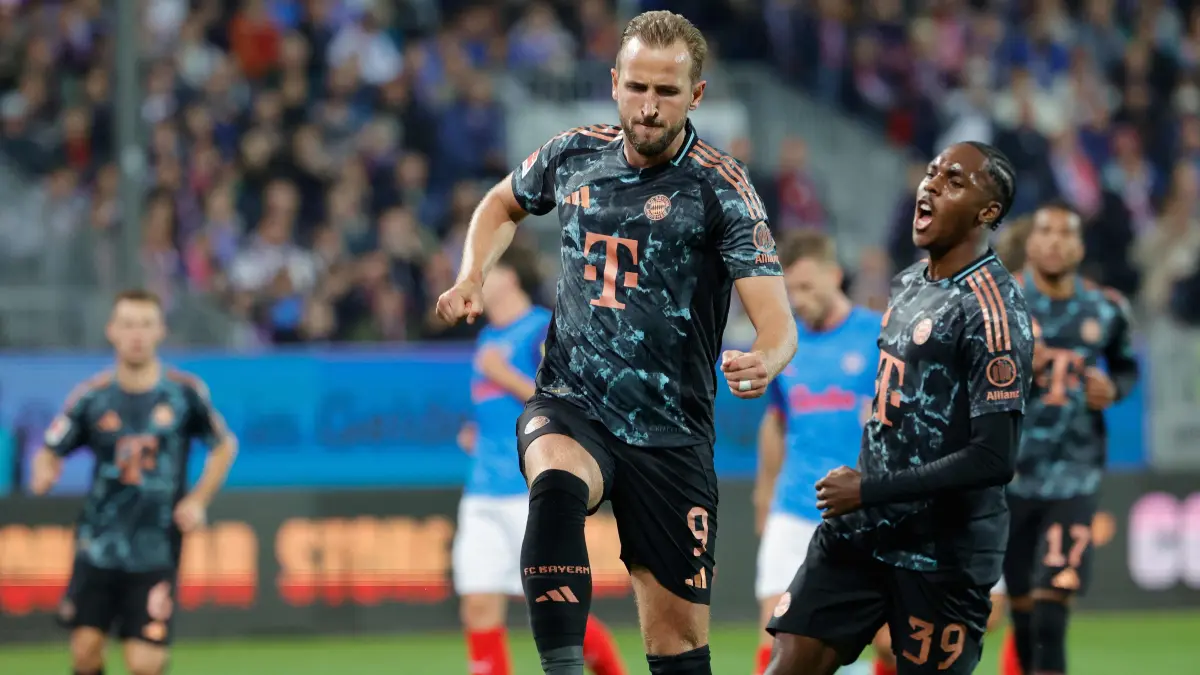 Bayern Munich's English forward #09 Harry Kane celebrates scoring from the penalty spot with his teammates during the German first division Bundesliga football match between Holstein Kiel and FC Bayern Munich in Kiel, northern Germany, on September 14, 2024. (Photo by AXEL HEIMKEN / AFP) / DFL REGULATIONS PROHIBIT ANY USE OF PHOTOGRAPHS AS IMAGE SEQUENCES AND/OR QUASI-VIDEO