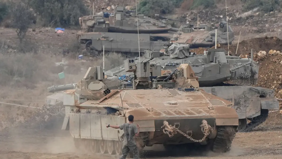 Nahostkonflikt - Israel: 01.10.2024, Israel, Nordisrael: Israelische gepanzerte Mannschaftstransportwagen (APC) und Panzer manövrieren in einem Bereitstellungsraum im Norden Israels nahe der israelisch-libanesischen Grenze. Foto: Baz Ratner/AP/dpa +++ dpa-Bildfunk +++