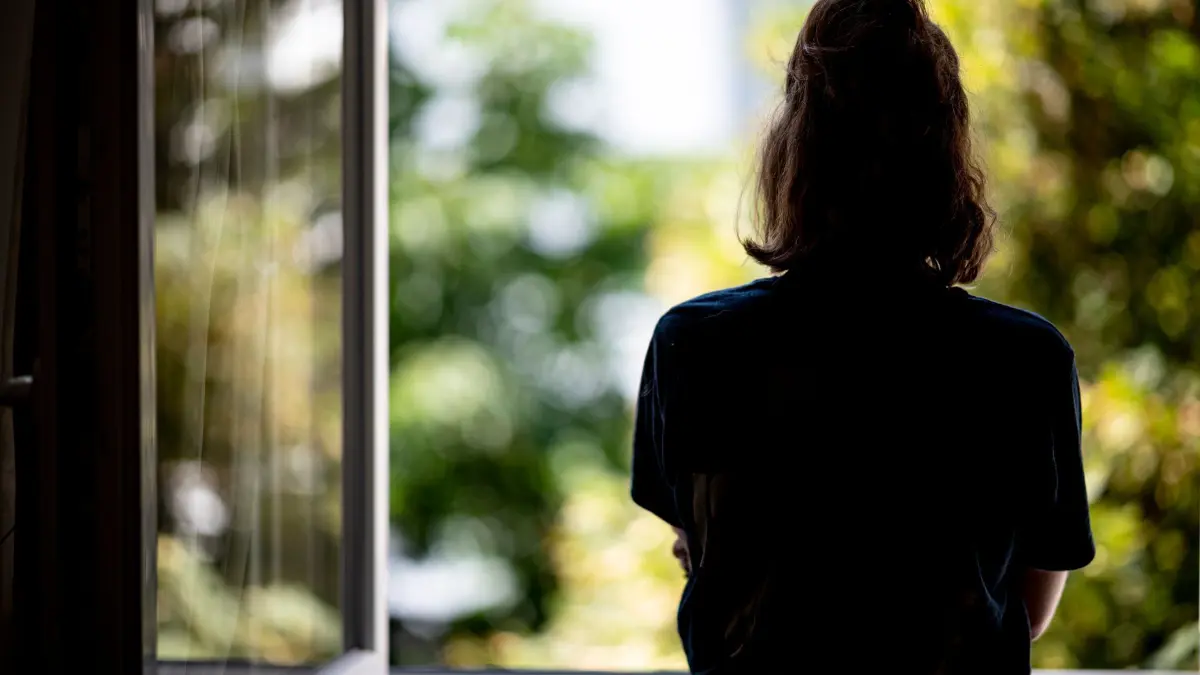 Symbolbild - Depression: ARCHIV - 13.07.2021, Berlin: ILLUSTRATION - Eine Frau steht in ihrer Wohnung an einem Fenster. (zu dpa: «AOK: Gut jeder zehnte Schleswig-Holsteiner hat Depressionen») Foto: Fabian Sommer/dpa +++ dpa-Bildfunk +++