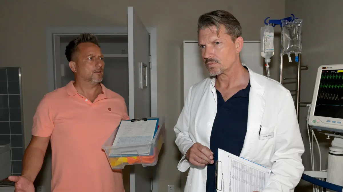 Michi (Lars Pape, l.) stört Lars (Hardy Krüger), der gerade einen kriminellen Patienten versorgen will.