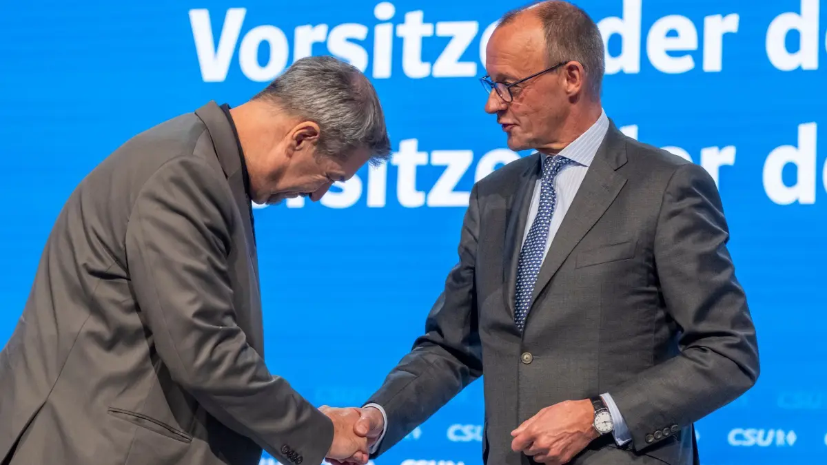 Abschluss Parteitag CSU: 12.10.2024, Bayern, Augsburg: Markus Söder (l), Vorsitzender der CSU, gibt Friedrich Merz (r), CDU-Bundesvorsitzender und Unionsfraktionsvorsitzender, nach dessen Rede auf dem Parteitag der CSU die Hand und verbeugt sich. Foto: Peter Kneffel/dpa +++ dpa-Bildfunk +++