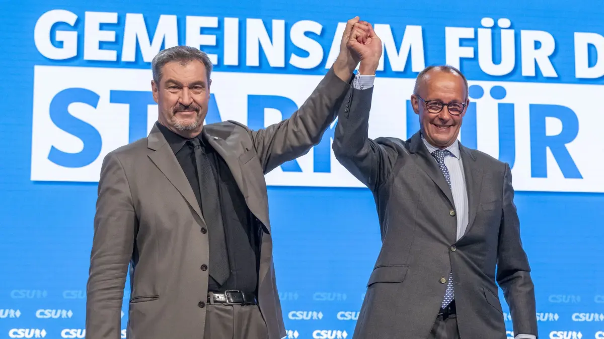12.10.2024, Bayern, Augsburg: Friedrich Merz (r), CDU-Bundesvorsitzender und Unionsfraktionsvorsitzender, und Markus Söder, Vorsitzender der CSU, stehen auf dem Parteitag der CSU zusammen auf der Bühne. Foto: Peter Kneffel/dpa +++ dpa-Bildfunk +++