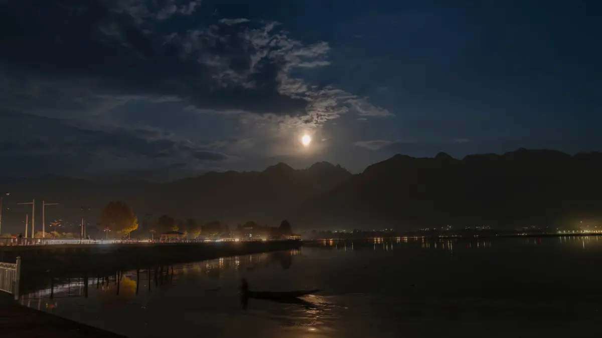 Supermond - Indien: 17.10.2024, Indien, Srinagar: Ein Supermond geht hinter den Zabarwan-Hügeln auf, während ein Bootsführer seine Shikara auf dem Dal-See am Stadtrand im indisch kontrollierten Kaschmir rudert. Foto: Dar Yasin/AP/dpa +++ dpa-Bildfunk +++