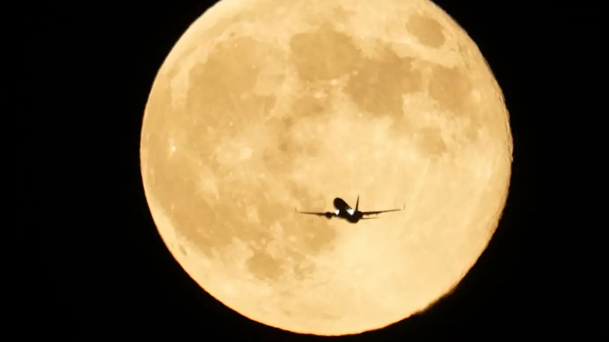 Supermond - Chicago: 17.10.2024, USA, Chicago: Ein Flugzeug fliegt vor dem Supermond, der über dem Michigansee aufgeht. Foto: Kiichiro Sato/AP/dpa +++ dpa-Bildfunk +++