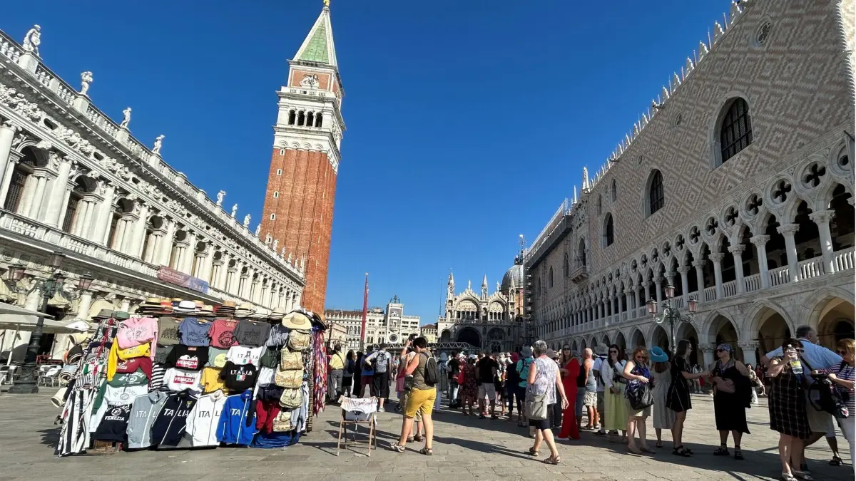 ARCHIV - 11.09.2023, Italien, Venedig: Touristen stehen auf dem Markusplatz mit Campanile (M) und Dogenpalast (r). (zu dpa: «Venedig will nach Test-Ende mehr Eintritt verlangen») Foto: Christoph Sator/dpa +++ dpa-Bildfunk +++