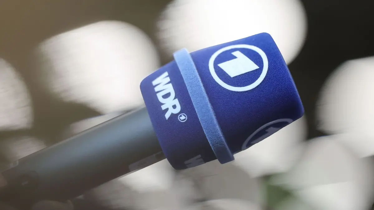 Öffentlich-rechtlicher Rundfunk - Mikrofon: 24.10.2024, Bayern, Nürnberg: Einkleidung der Athleten des DSV (Deutscher Skiverband) im MesseCongressCentrum. Ein Mikrofon des ARD und des WDR (Westdeutscher Rundfunk). Foto: Daniel Löb/dpa +++ dpa-Bildfunk +++