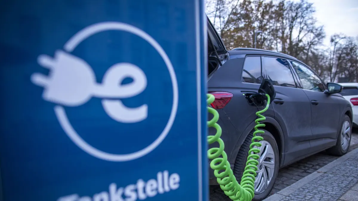 SYMBOLBILD - 28.11.2023, Mecklenburg-Vorpommern, Schwerin: An der Ladesäule eines regionalen Stromanbieters wird ein Elektroauto mit Strom aufgeladen. Anhaltend hohe Stromtarife an öffentlichen Ladesäulen könnten Menschen laut Branchenexperten von einem Umstieg auf Elektroautos abhalten. (zu dpa: «Experten: Dauerhaft hohe Ladestrompreise bremsen Umstieg auf E-Autos») Foto: Jens Büttner/dpa +++ dpa-Bildfunk +++