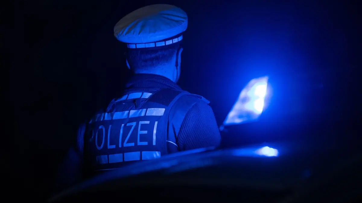 Illustration - Polizei: ILLUSTRATION - 30.11.2023, Baden-Württemberg, Stuttgart: Ein Polizist steht im Rahmen eines Fototermins neben einem Polizeifahrzeug. (zu dpa: «Polizei fahndet nach Paar - Durchsuchung mit SEK») Foto: Marijan Murat/dpa +++ dpa-Bildfunk +++