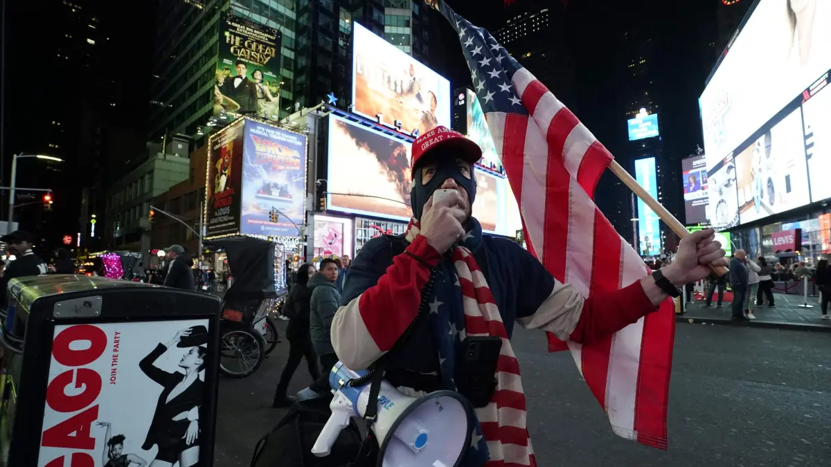 A supporter of former US President and Republican presidential candidate Donald Trump talks on a megaphone in New York's Times Square in New York on November 5, 2024. (Photo by TIMOTHY A. CLARY / AFP)