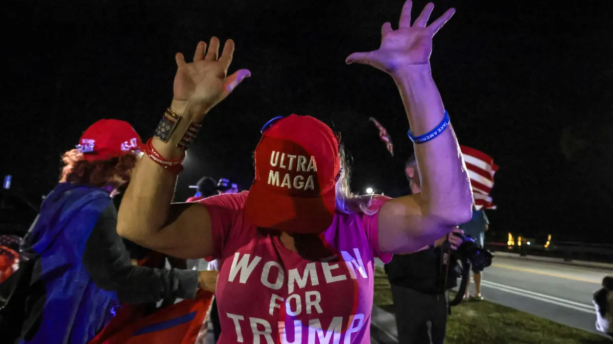 A supporter of former US president and Republican presidential candidate Donald Trump gestures as they gather near his Mar-a-Lago resort in Palm Beach, Florida, on Election Day, November 5, 2024. (Photo by Giorgio Viera / AFP)