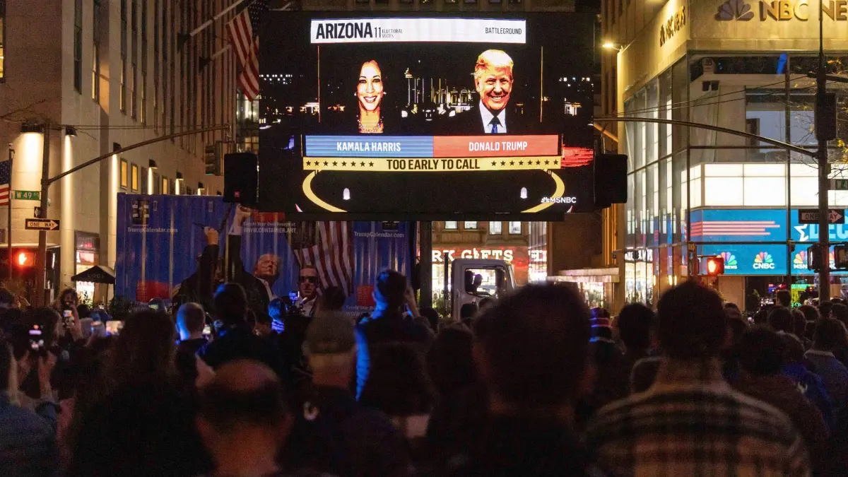 US-Wahlen 2024 - New York: 05.11.2024, USA, New York: Menschen verfolgen einen Livestream von NBC News mit den Wahlergebnissen im Rockefeller Center in New York am Wahltag. Foto: Yuki Iwamura/FR171758 AP/dpa +++ dpa-Bildfunk +++