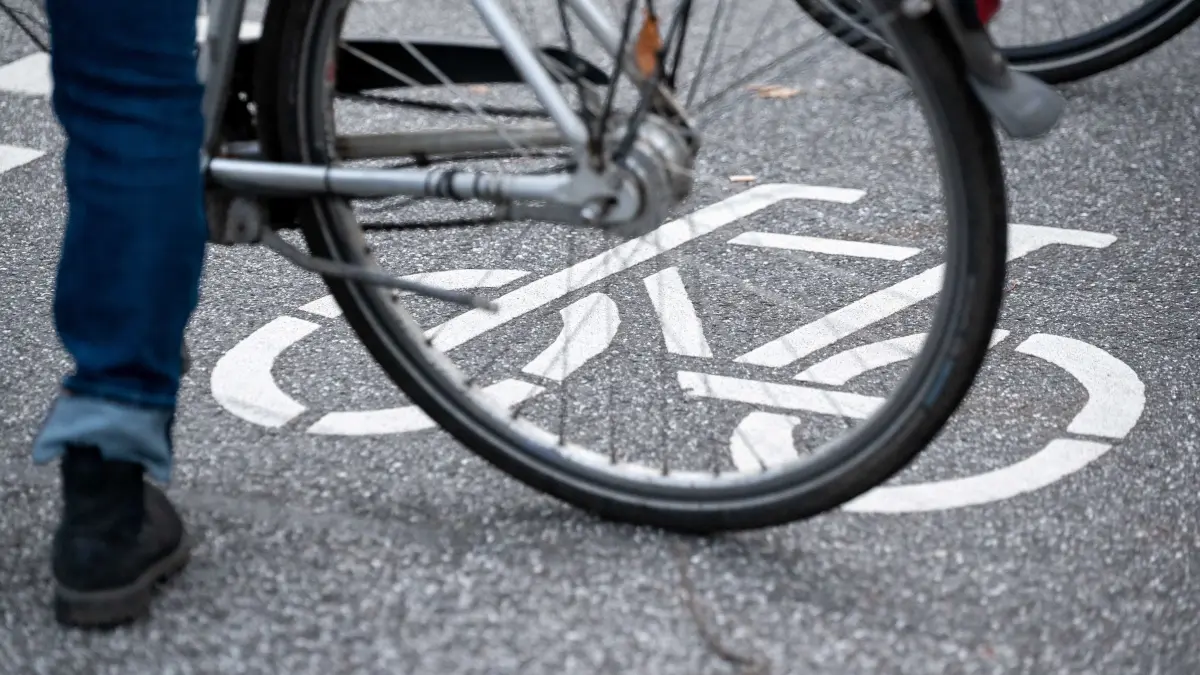 ARCHIV - 31.10.2021, Hamburg: Ein Fahrrad-Symbol ist auf der Fahrbahn einer Straße hinter einem Fahrrad zu sehen. (zu dpa: «Radfahrer nach Sturz im Krankenhaus gestorben») Foto: Jonas Walzberg/dpa +++ dpa-Bildfunk +++