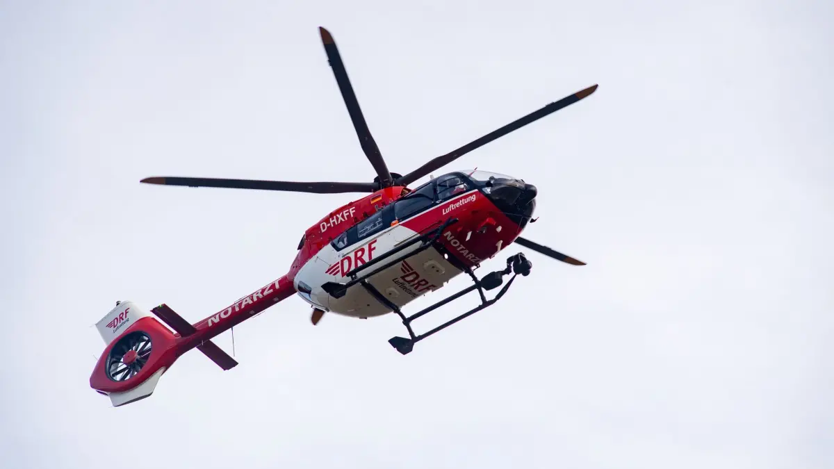 Rettungshubschrauber - Symbolbild: ARCHIV - 10.11.2023, Mecklenburg-Vorpommern, Greifswald: Ein Rettungshubschrauber fliegt zur Notaufnahme einer Klinik. Eine Autofahrerin ist bei einem Zusammenstoß mit einem Baum im Landkreis Ostallgäu schwer verletzt worden. (zu dpa: «Vierter Rettungshubschrauber in MV soll nach Pampow») Foto: Stefan Sauer/dpa +++ dpa-Bildfunk +++