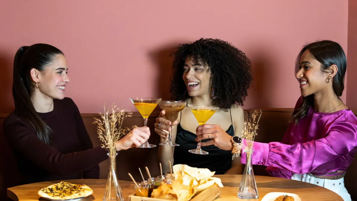 Young women toasting drinks while sitting at dining table model released Symbolfoto property released PNAF01723: Young women toasting drinks while sitting at dining table model released Symbolfoto property released PNAF01723