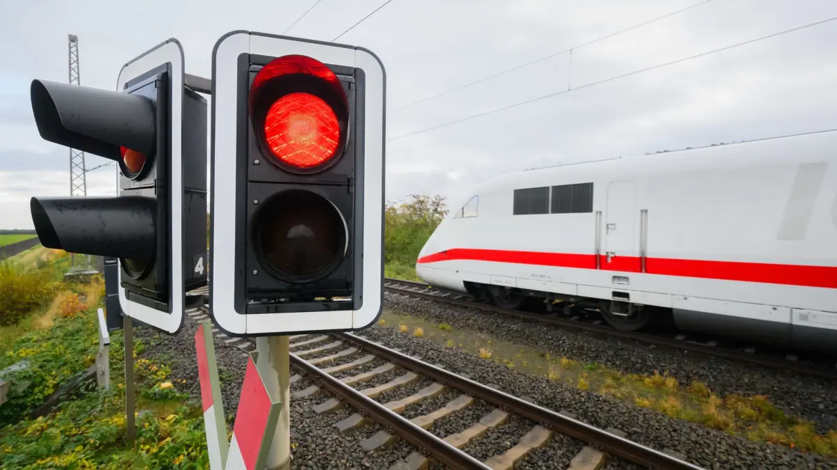 ARCHIV - 15.11.2023, Niedersachsen, Schellerten: Eine rote Ampel leuchtet an einem Bahnübergang als ein ICE der Deutschen Bahn auf der Strecke Hildesheim - Berlin fährt. Die Gewerkschaft Deutscher Lokomotivführer (GDL) will erneut die Deutsche Bahn bestreiken. (zu dpa «Gewerkschaft GDL will Deutsche Bahn erneut bestreiken - Termin offen»9 (zu dpa: «Bahnstrecke Mannheim-Stuttgart 2025 wochenlang gesperrt») Foto: Julian Stratenschulte/dpa +++ dpa-Bildfunk +++